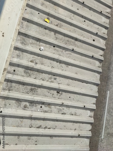Fotografie Top view of a weathered corrugated concrete roof panel with debris