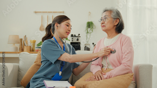 Quadro su tela Caregiver nursing home elderly care senior woman medical examination living room