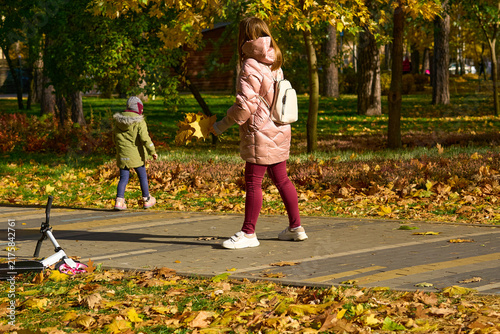 Family.Mother in pink jacket with preschool daughter walking in forest park