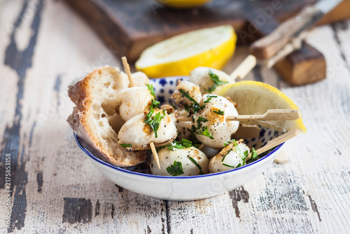 Tapas, grilled sepia, lemon and bread in bowl