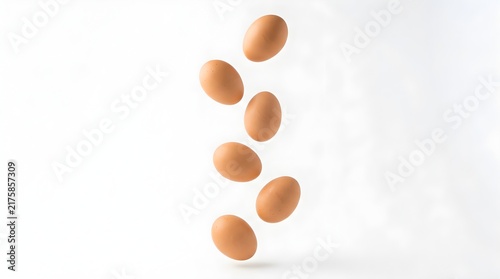 Fresh brown chicken eggs falling in air isolated on a clean white background