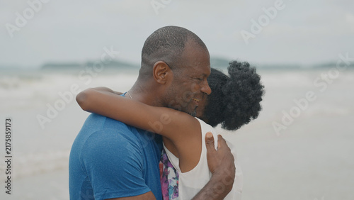Принти на полотні A Black couple shares a warm, emotional embrace on a beach