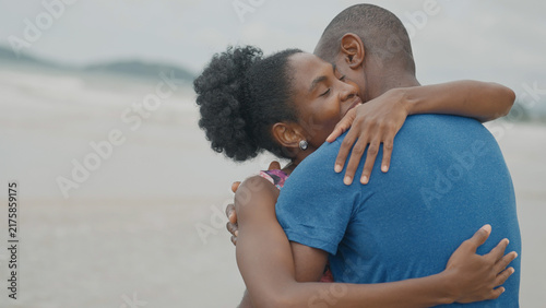 Принти на полотні A Black couple shares a warm, emotional embrace on a beach