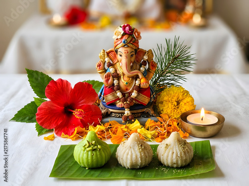 Lord Ganesha idol with Modak sweets and flowers for Ganesh Chaturthi festival celebration