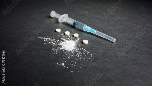 Obraz na płótnie Sealed 3ml syringe and white drugs in powder and pills form