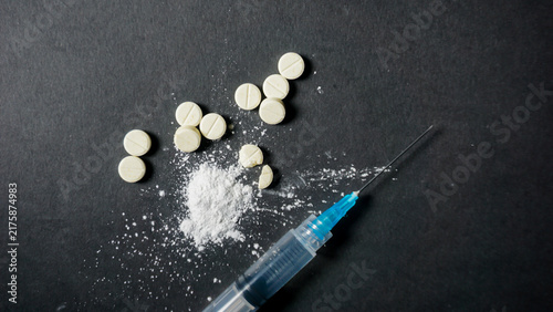 Obraz na płótnie Top view of some pills and syringe on black background