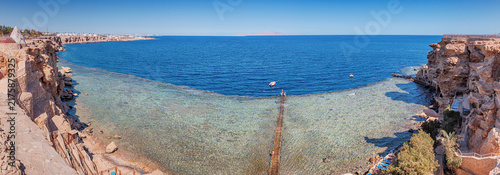 Cuadro en lienzo Idyllic Red Sea view from a rocky cliff, beach umbrellas, sun loungers, and clea