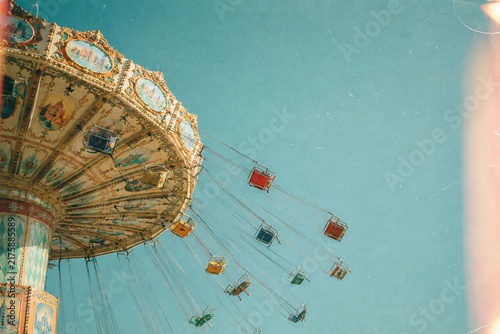 Ornate swing carousel against bright clear blue sky