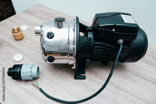 Stainless steel surface water pump set with plastic pipe fittings brass valve and power cable on wooden table
