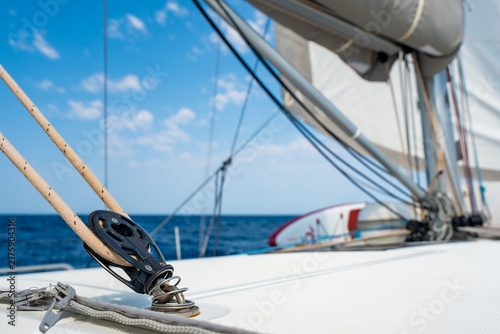 Sailboat deck hardware with rope and pulley under sail. Yacht rigging and sailing equipment during navigation at sea.