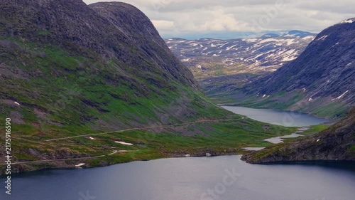 Aerial view  of the winding highway hugging the edge of the deep blue Djupvatnet lake in Norway
