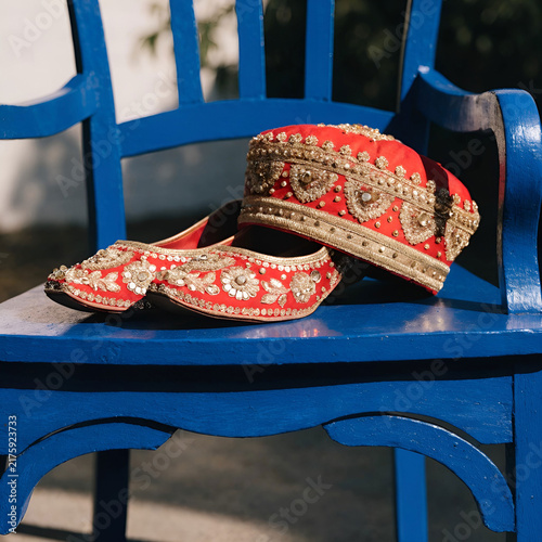 red Indian groom shoes and hat lie on the blue