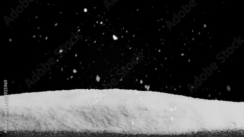 Snow falls on a wooden floor with a pile of snow