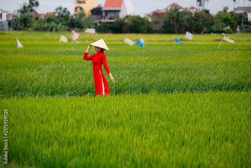 Canvastavla Woman tourist in red ao dai posing in lush green rice field near hoi an, danang