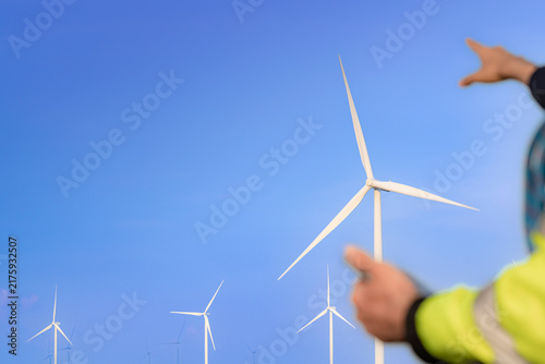 Fotografie The sky deepens to a rich blue as a technician holds his fingers above a tall wh