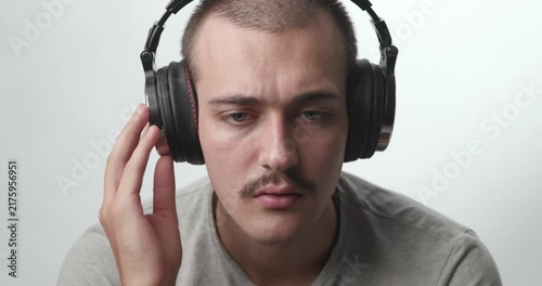 Close-up of Young Man Wearing Headphones Listening to Music and Smiling at Camera