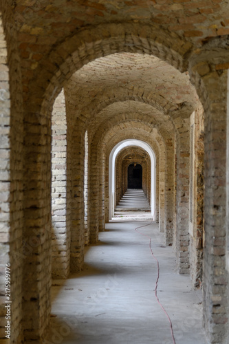 Foto Vaulted brick arcade with receding arches in the old fortress casemates of Komar