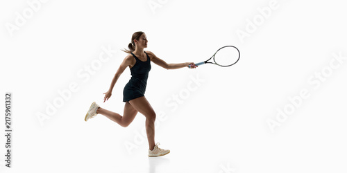 Obraz na plátně Female tennis player running forward for extended forehand shot on white studio background