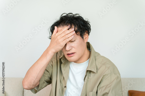 Konstfotografi A middle-aged man with a fever and feeling unwell holds his hand to his forehead
