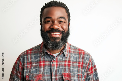 Smiling man with beard wearing plaid shirt against white background