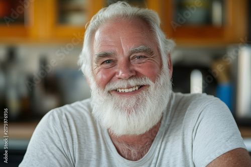 Portrait of an older man with a beard smiling in a kitchen setting