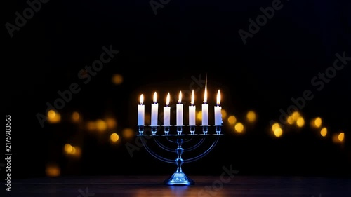 Silver Menorah with Seven Burning Candles on a Wooden Table in Dark Room with Bokeh Lights Background