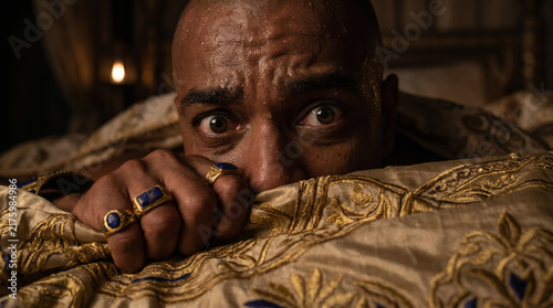 Pharaoh waking up in a cold sweat from his terrifying nightmare of seven gaunt cows devouring seven fat cows