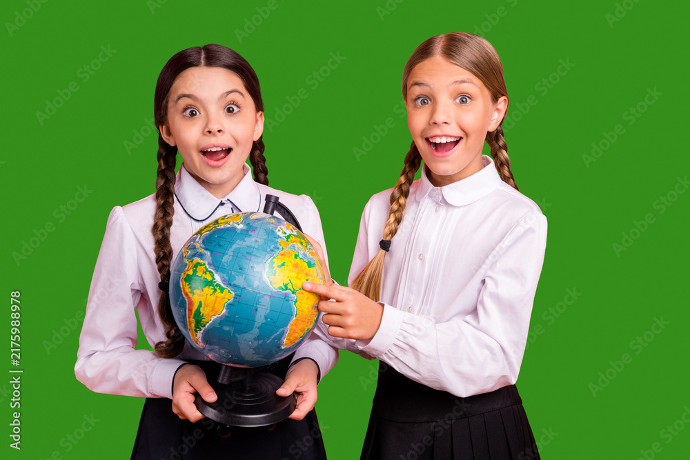 Fototapeta premium Portrait of two person nice attractive lovely charming cute cheerful cheery amazed funny pre-teen girls finding map new route destination isolated over bright vivid shine orange background