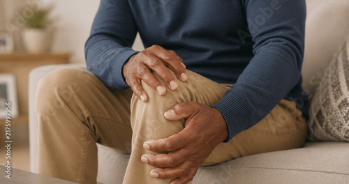 Fotografía Elderly man experiencing joint pain while holding his sore knee at home,  knee p