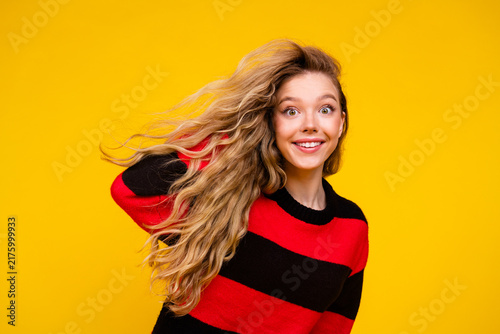 Canvastavla Charming young woman in a striped sweater posing against a yellow background rad