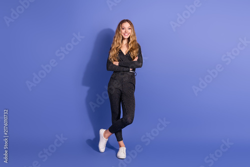 Картината върху платно Young fashion model wearing a striped jumpsuit stands confidently against a viol