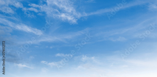 Clear blue sky with wispy clouds drifting gently