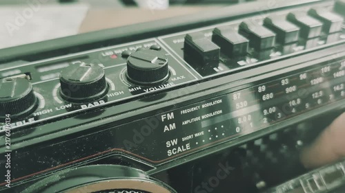 Removing a cassette from an old dusty tape recorder from the eighties in a cozy living room