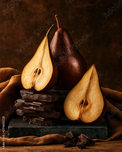 Pear and dark chocolate still life on rustic table