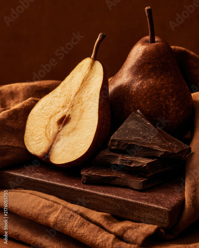 Pear and dark chocolate still life on rustic fabric
