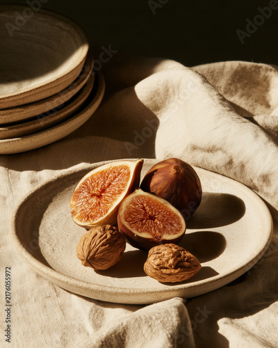 Fresh fig and walnut on ceramic plate in sunlight