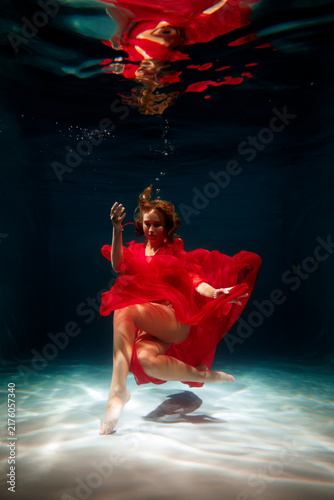 Photography Crimson dressed female swiftly crossing reflective water
