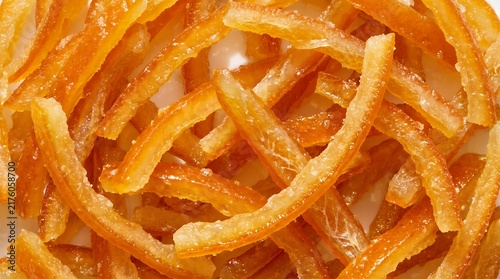 Closeup of delicious candied orange peel strips, sweet citrus zest snack, bright orange texture, food photography