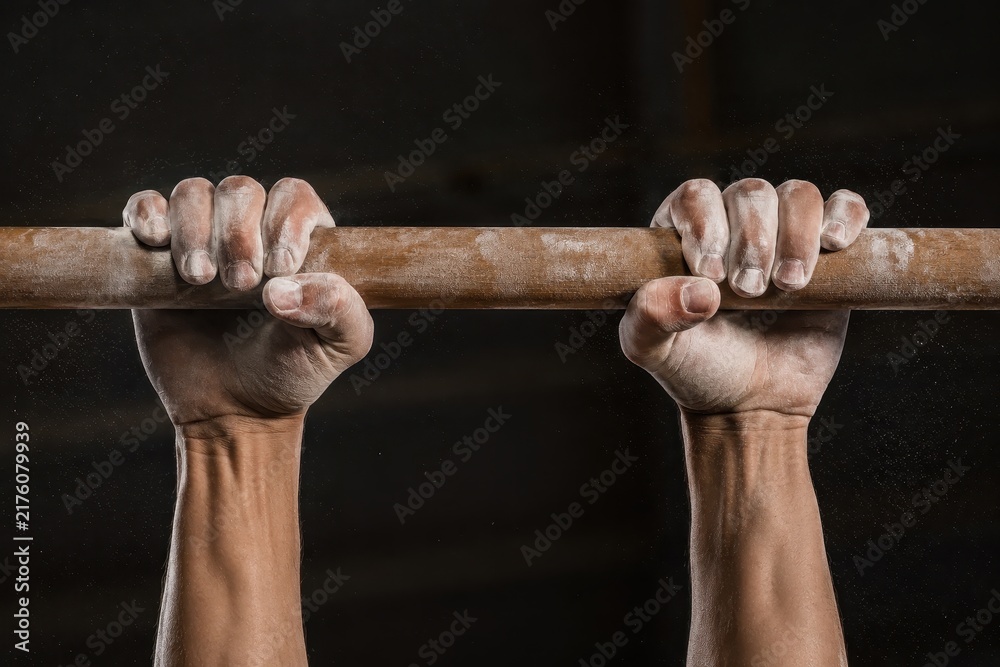 Fototapeta premium Chalked hands gripping a gymnastics bar