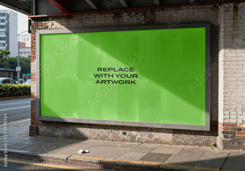 Large outdoor billboard mockup with placeholder screen mounted on a brick wall at street corner, realistic urban advertising display natural sunlight and sidewalk environment