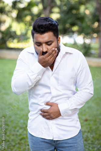 Fotografía young adult south asian man in his 20s feeling nauseous and about to vomit in ou