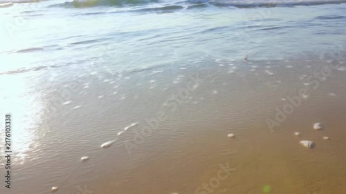 Waves sweep over the sand on the beach.