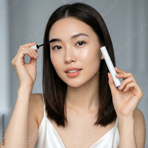 Young woman applying eyebrow makeup with precision highlighting beauty enhancement process