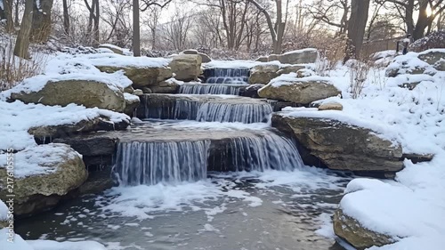 Snow Covered Japanese Garden Waterfalls Cascade over Natural Rocks in a Peaceful Winter Landscape Video