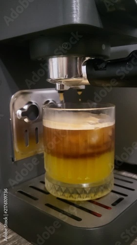 Close up of coffee machine brewing layered bumble coffee with citrus juice, modern cafe service, refreshing morning routine, barista skills.