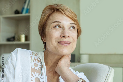 Ceerful smiling 55 years old woman at home portrait