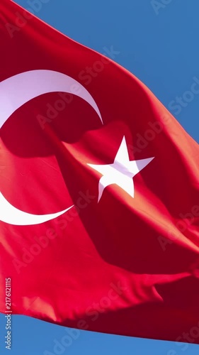 Turkish flag waving proudly in the wind against a clear blue sky, capturing the majestic details of the crescent and star in high-quality 4K footage, perfect for national holidays, patriotic themes, a