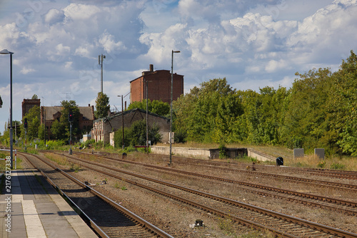 Ansicht des historischen Bahnhofsgebäudes mit Gleisanlagen und Bahnsteigen in Könnern an einem sonnigen Tag, Salzlandkreis, Sachsen-Anhalt, Deutschland