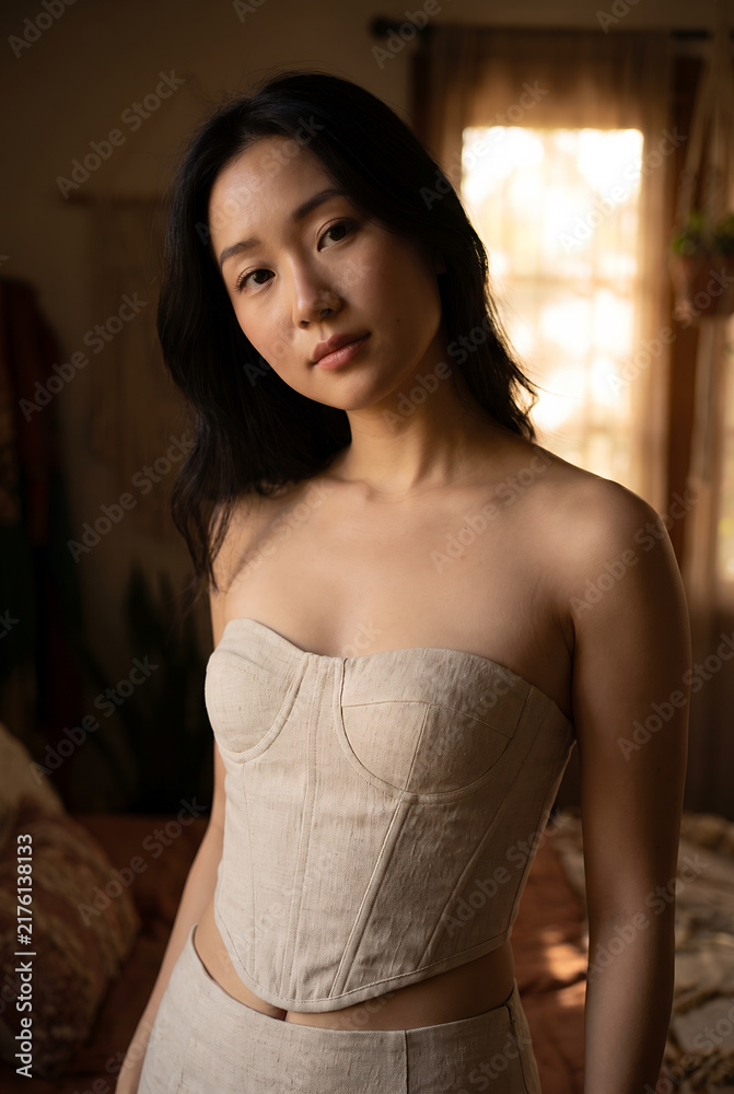 Fototapeta premium Young Asian woman wearing linen corset in warm natural light