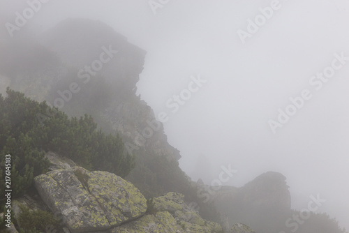 Felsiger Berggipfel im Nebel unter bedecktem Himmel